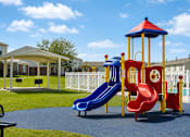 Thumbnail 10 of 23 - A playground with a red slide and a blue slide.