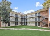 Thumbnail 29 of 31 - an exterior view of an apartment building with grass and trees at The Courts Midtown, Memphis