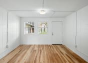 Thumbnail 20 of 31 - an empty room with white walls and wood floors at The Courts Midtown, Memphis, TN