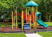 Thumbnail 7 of 26 - A playground with a green slide and a blue roofed structure.