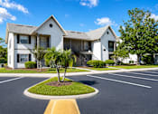 Thumbnail 23 of 26 - A white apartment building with a yellow curb in front.