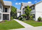 Thumbnail 25 of 26 - A row of houses with a sidewalk in front.