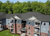 Thumbnail 1 of 4 - Apartment complex with multiple buildings and green lawns.