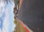 Thumbnail 15 of 16 - A red line on a black surface with a white car in the background.