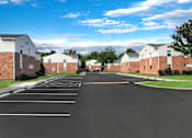 Thumbnail 18 of 25 - A parking lot with a road in the middle and buildings on both sides.