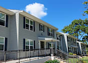 Thumbnail 2 of 3 - a gray apartment building with a balcony and a blue sky