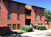 Thumbnail 15 of 21 - A red brick building with a black railing on the balcony.