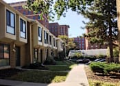 Thumbnail 5 of 21 - A long row of identical buildings with a sidewalk in front of them.