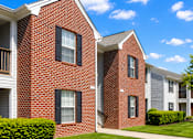Thumbnail 2 of 19 - A row of red brick houses with green bushes in front.