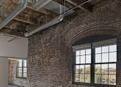 Thumbnail 14 of 16 - A large empty room with a brick wall and a large window.at South Main Artspace Lofts, Memphis, TN 38126