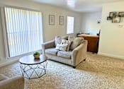 Thumbnail 6 of 17 - A living room with a couch, chair, and coffee table.