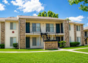 Thumbnail 2 of 5 - Apartment building with a green lawn in front.