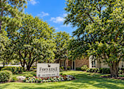 Thumbnail 10 of 33 - A sign for Fawn Ridge Apartments is in front of a building and trees.