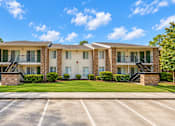 Thumbnail 11 of 33 - A sunny day at a residential complex with a clear blue sky.