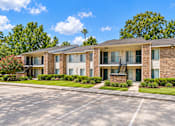 Thumbnail 17 of 33 - A brick apartment building with a green lawn in front.