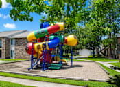 Thumbnail 3 of 5 - A colorful playground structure with a slide in the middle of a grassy area.