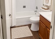 Thumbnail 24 of 33 - A white bathroom with a toilet, sink, and shower.