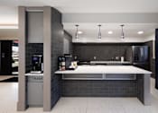 Thumbnail 23 of 28 - A modern kitchen with a trash bin labeled