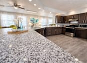 Thumbnail 1 of 21 - A kitchen with granite countertops and stainless steel appliances.