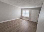 Thumbnail 15 of 21 - A room with a wooden floor and a white door.