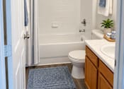 Thumbnail 14 of 15 - A bathroom with a toilet, sink, and shower.