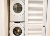 Thumbnail 28 of 43 - Two white washing machines are stacked in a white cabinet.