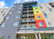Thumbnail 33 of 43 - A multi-story building with a colorful design on the side and a sign that reads "Fishhooks".