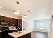Thumbnail 26 of 43 - A kitchen with dark brown cabinets and a white countertop.