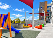 Thumbnail 21 of 43 - A playground with a blue slide and a red flag.