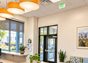 Thumbnail 22 of 43 - A modern office with a desk, chairs, and a potted plant.