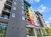 Thumbnail 15 of 43 - A multi-story building with a Community Living sign on the front.
