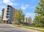 Thumbnail 41 of 43 - A modern apartment building with balconies and trees in front.