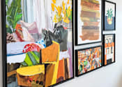 Thumbnail 39 of 43 - A wall with a painting of a yellow chair and a painting of a pineapple on it.