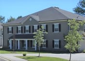 Thumbnail 6 of 13 - a large gray house with trees in front of it