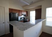 Thumbnail 2 of 13 - an empty kitchen with a granite counter top