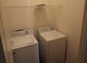 Thumbnail 11 of 13 - two washing machines in a small room with a door