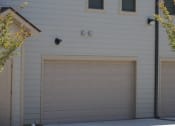 Thumbnail 8 of 13 - a garage door on the side of a white house