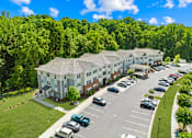 Thumbnail 5 of 10 - A large building with a parking lot in front of it.