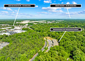 Thumbnail 10 of 10 - An aerial view of a wooded area with a road and three white arrows pointing to text boxes with addresses and driving times.