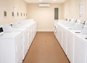 Thumbnail 7 of 7 - A laundromat with rows of washers and dryers.