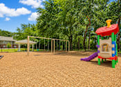 Thumbnail 7 of 12 - A playground with a slide, swings, and a climbing frame.