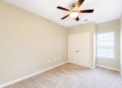 Thumbnail 12 of 12 - A room with a ceiling fan and a white door.