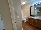 Thumbnail 15 of 15 - A bathroom with a toilet, sink, and mirror.