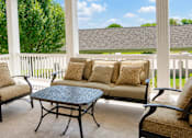 Thumbnail 4 of 19 - A patio with a table and chairs with a view of the backyard.