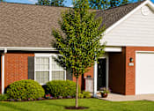 Thumbnail 11 of 19 - A house with a white garage door and a tree in front.