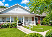 Thumbnail 10 of 19 - A house with a white porch and a white railing.