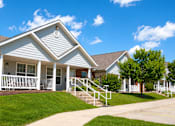 Thumbnail 13 of 19 - A house with a white porch and a brown roof.