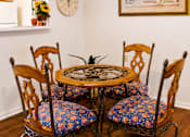 Thumbnail 16 of 19 - A table with four chairs and a clock on the wall.