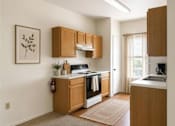 Thumbnail 3 of 5 - A kitchen with wooden cabinets and a rug on the floor.