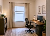 Thumbnail 5 of 5 - A room with a desk, chair, and a window with curtains.